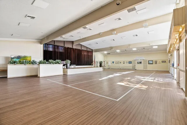 a view of an empty room with kitchen and a window