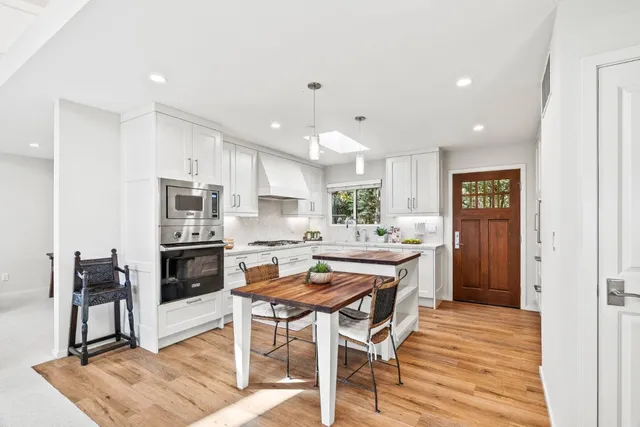 a kitchen with stainless steel appliances kitchen island granite countertop a refrigerator and a stove top oven