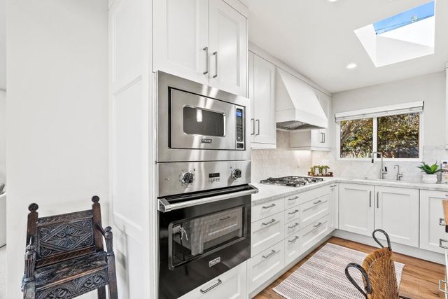 a kitchen with stainless steel appliances a stove microwave and cabinets