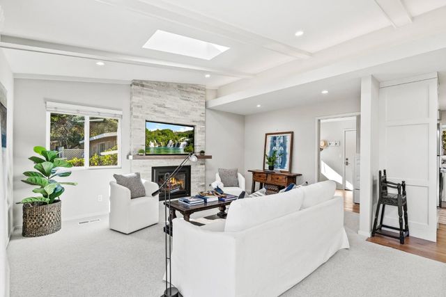 a living room with fireplace furniture and a potted plant
