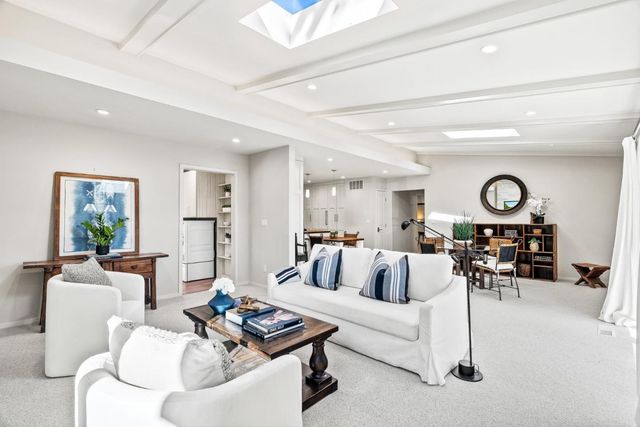 a living room with furniture and view of kitchen