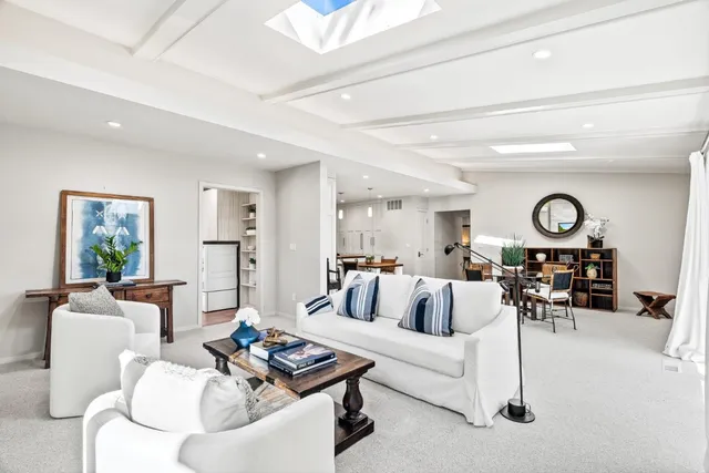 a living room with furniture and view of kitchen