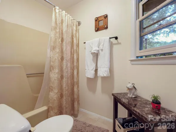 a bathroom with a toilet and a shower curtain