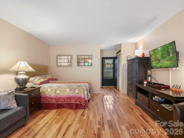 a bedroom with a bed and wooden floor