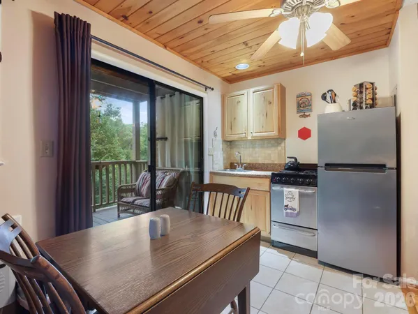 a kitchen with a stove a refrigerator and a dining table