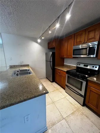a kitchen with stainless steel appliances granite countertop a sink and a stove