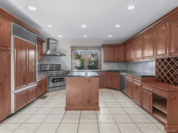 a kitchen with stainless steel appliances granite countertop a stove a sink and a refrigerator