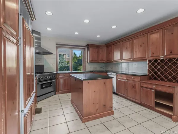 a kitchen with stainless steel appliances granite countertop a refrigerator and a stove top oven