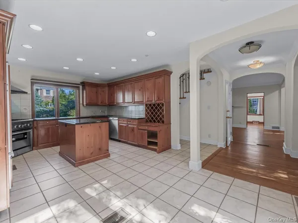 a kitchen with stainless steel appliances kitchen island granite countertop a refrigerator and a sink