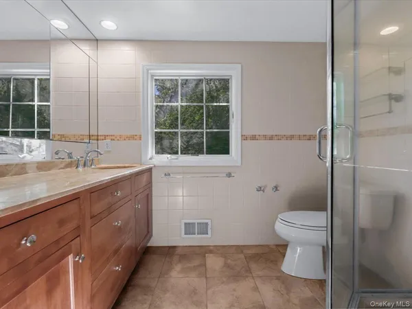 a bathroom with a double vanity sink toilet and shower