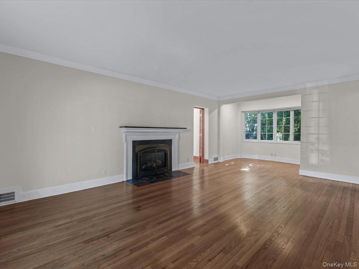 2 Amherst Road Great Neck, NY 11021 - Photo 4 of 45 an empty room with wooden floor fireplace and windows