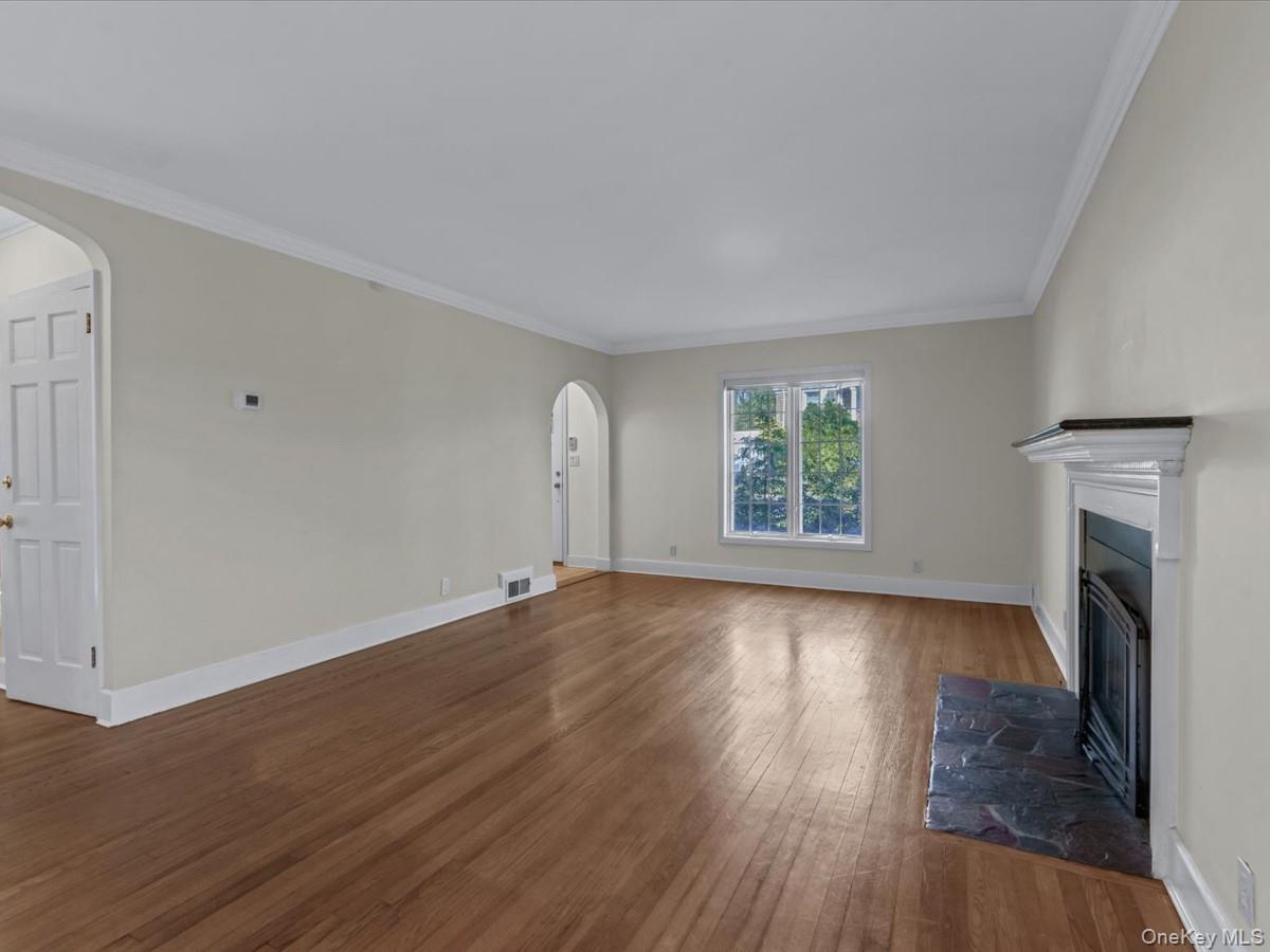 2 Amherst Road Great Neck, NY 11021 - Photo 6 of 45 an empty room with wooden floor fireplace and windows