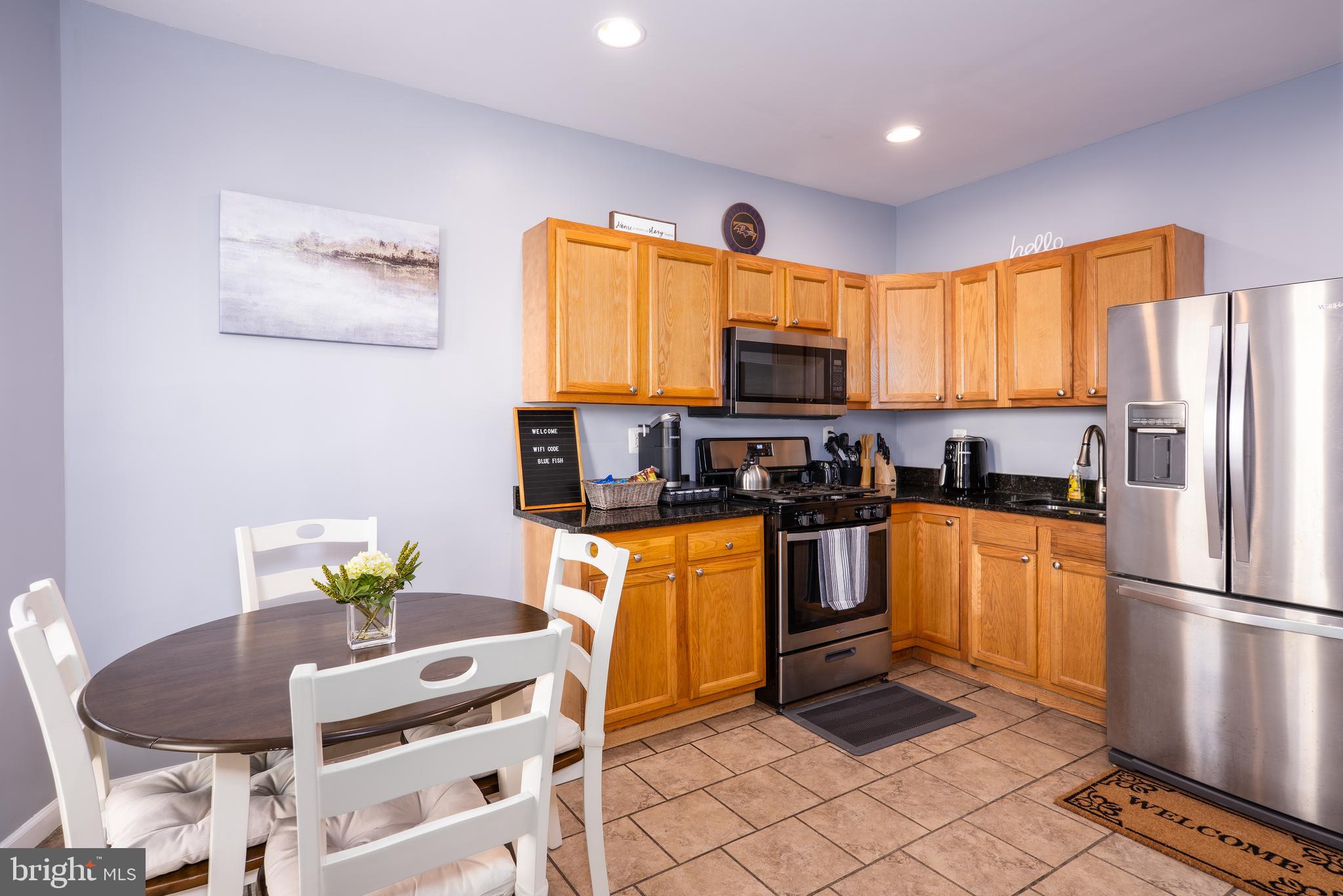 1247 Carroll Street Baltimore, MD 21230 - Photo 19 of 24 a kitchen with stainless steel appliances granite countertop a refrigerator a stove a sink a dining table and chairs