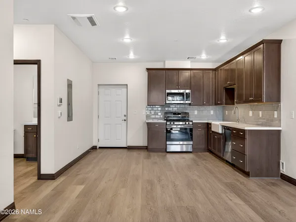 a kitchen with stainless steel appliances a refrigerator and a stove top oven