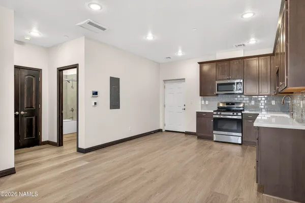 a kitchen with granite countertop a refrigerator and a stove top oven