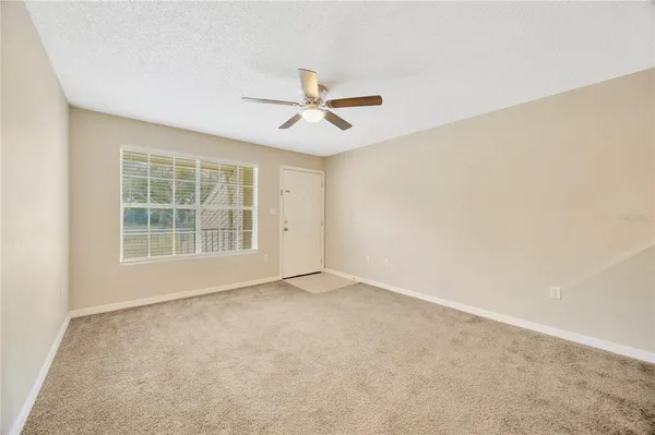 an empty room with closet and a ceiling fan
