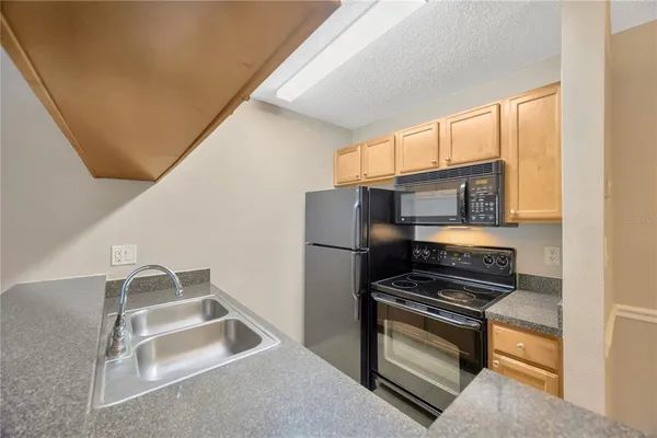 a kitchen with stainless steel appliances granite countertop a refrigerator and a stove
