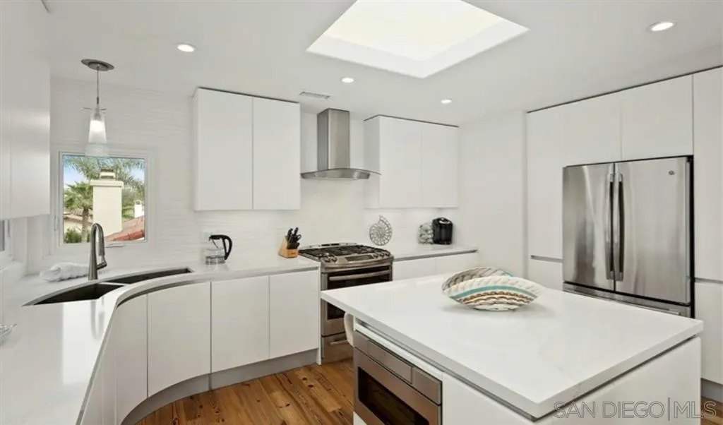 6512 Surfside Lane Carlsbad, CA 92011 - Photo 11 of 26 a kitchen with a white stove top oven and refrigerator