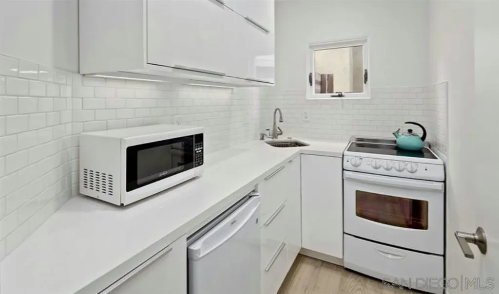 6512 Surfside Lane Carlsbad, CA 92011 - Photo 21 of 26 a kitchen with cabinets and steel appliances