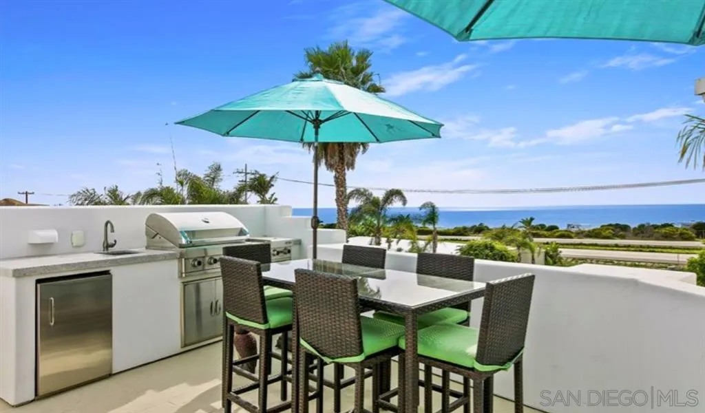 6512 Surfside Lane Carlsbad, CA 92011 - Photo 25 of 26 a view of an outside dining space with furniture and umbrella