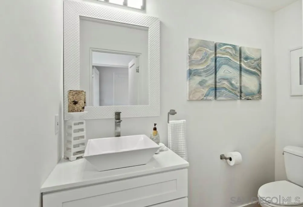 6512 Surfside Lane Carlsbad, CA 92011 - Photo 10 of 26 a bathroom with a sink mirror and toilet