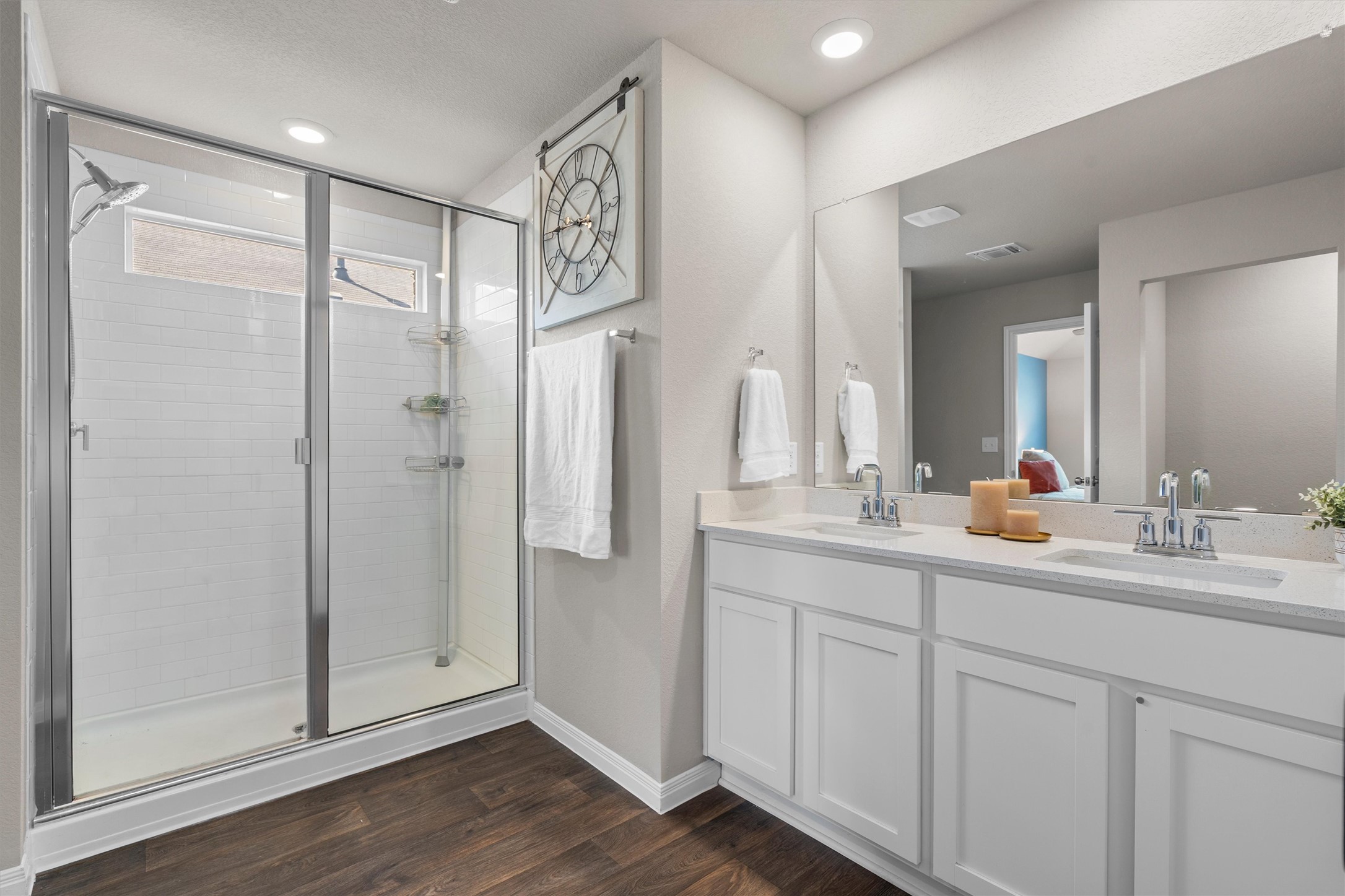 19525 Abigail Fillmore Road Manor, TX 78653 - Photo 16 of 38 Dual vanity with bright lighting and a spacious glass-enclosed shower.