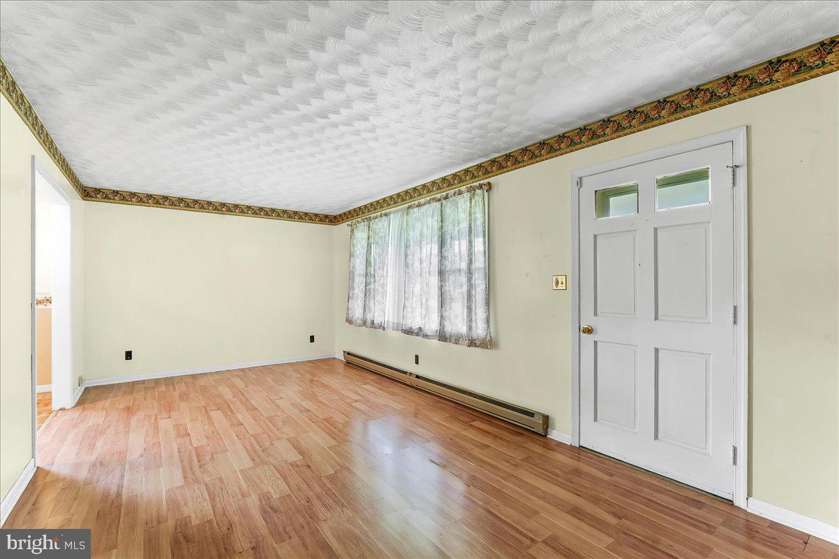 374 Street Road Cochranville, PA 19330 - Photo 5 of 28 an empty room with wooden floor and windows