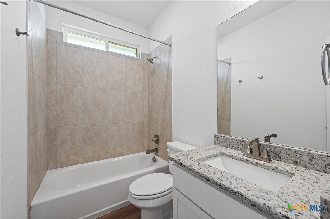 7906 Timber Holw Lane Temple, TX 76502 - Photo 11 of 29 a bathroom with a granite countertop sink toilet mirror and shower
