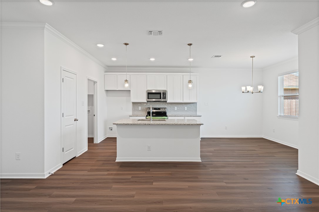 7906 Timber Holw Lane Temple, TX 76502 - Photo 14 of 29 a view of kitchen with granite countertop refrigerator oven a sink and white cabinets with wooden floor