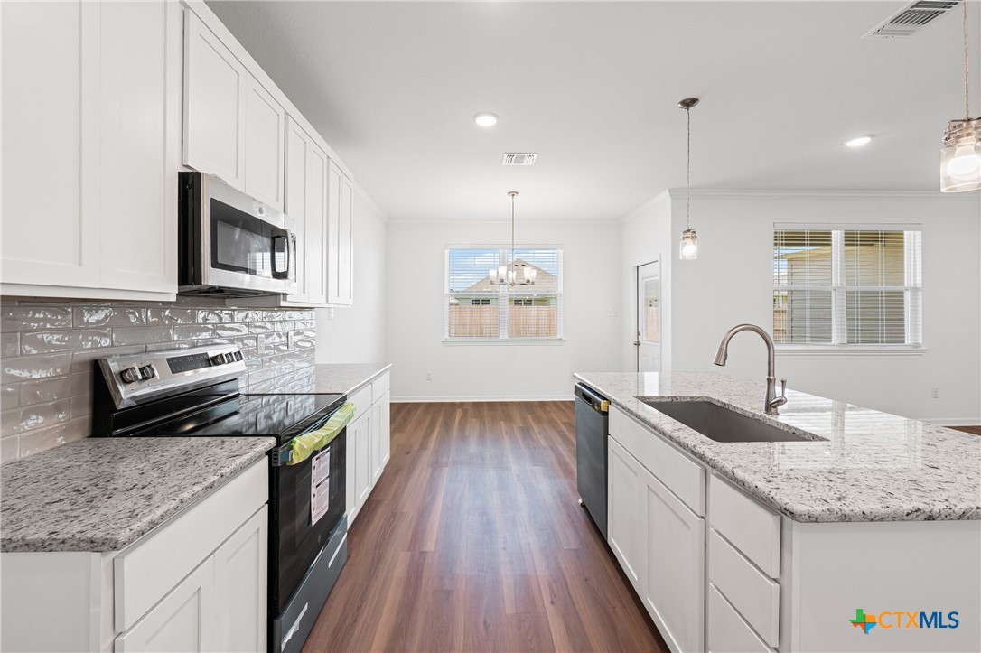 7906 Timber Holw Lane Temple, TX 76502 - Photo 19 of 29 a kitchen with granite countertop a sink stainless steel appliances and cabinets