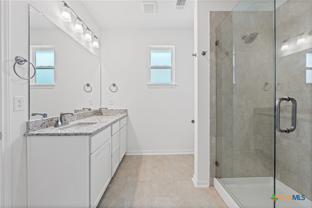 7906 Timber Holw Lane Temple, TX 76502 - Photo 26 of 29 a bathroom with a granite countertop sink two mirror and shower