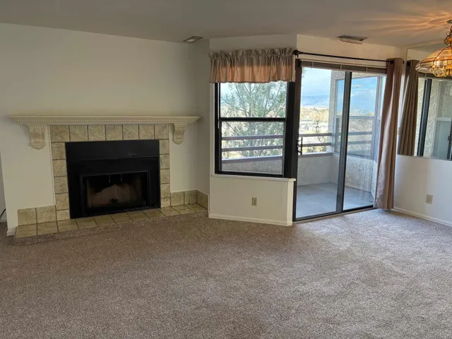 an empty room with windows and fireplace