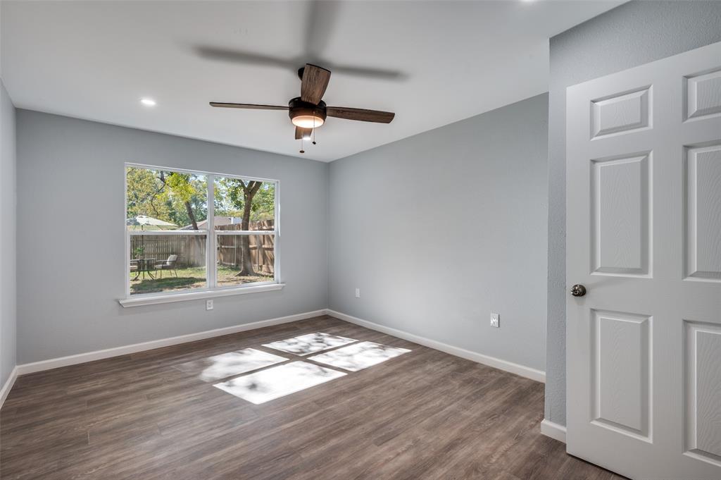 718 Glen Rhea Drive Lake Dallas, TX 75065 - Photo 12 of 23 an empty room with wooden floor ceiling fan and windows