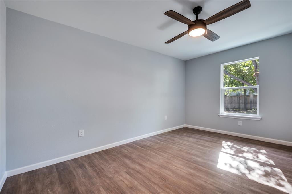 718 Glen Rhea Drive Lake Dallas, TX 75065 - Photo 17 of 23 an empty room with wooden floor and windows