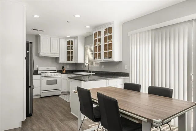 a kitchen with a stove a sink a table and chairs