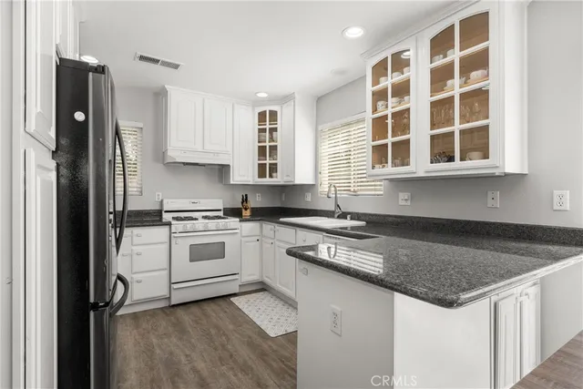 a kitchen with stainless steel appliances granite countertop a stove a sink and a refrigerator