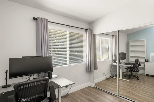 a view of a workspace with furniture and a window