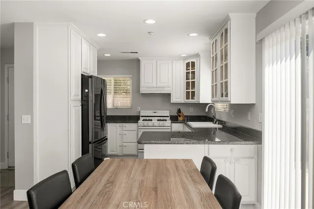 a kitchen with stainless steel appliances granite countertop a refrigerator and a stove top oven