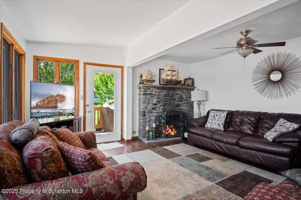 a living room with fireplace furniture and a large window