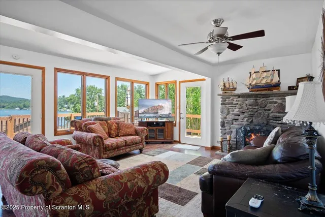 a living room with furniture ceiling fan and a floor to ceiling window