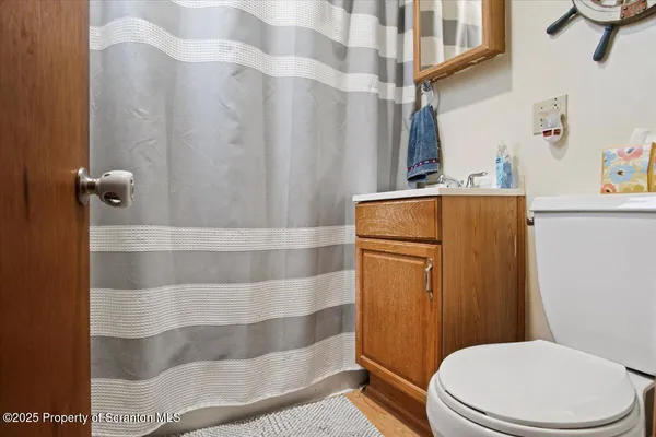 a bathroom with a toilet and a shower curtain