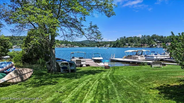 a view of a lake with lawn chairs under an umbrella