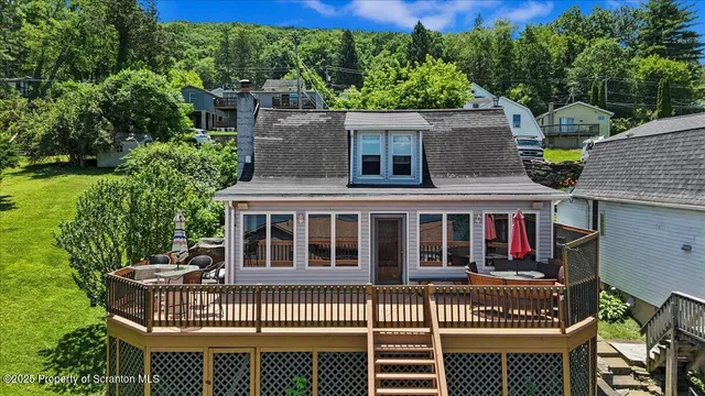 a view of a house with a deck and a yard