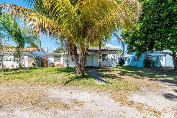 a view of a house with a yard and tree s