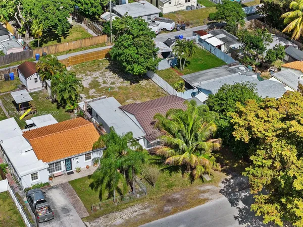 an aerial view of residential house with outdoor space and trees all around