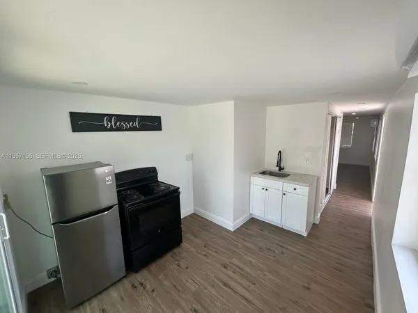 a kitchen with a refrigerator and a stove top oven