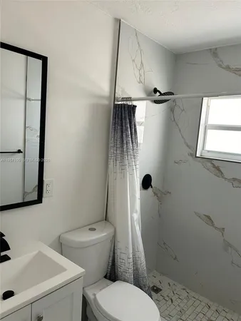a bathroom with a toilet sink and shower