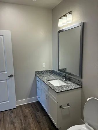 a bathroom with a granite countertop sink and a mirror