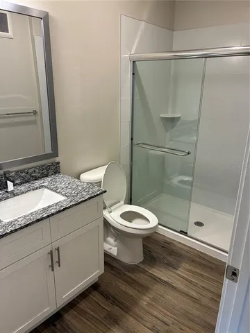 a bathroom with a granite countertop sink toilet and shower