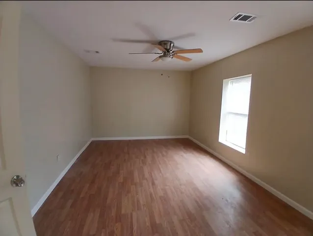 wooden floor in an empty room with a window